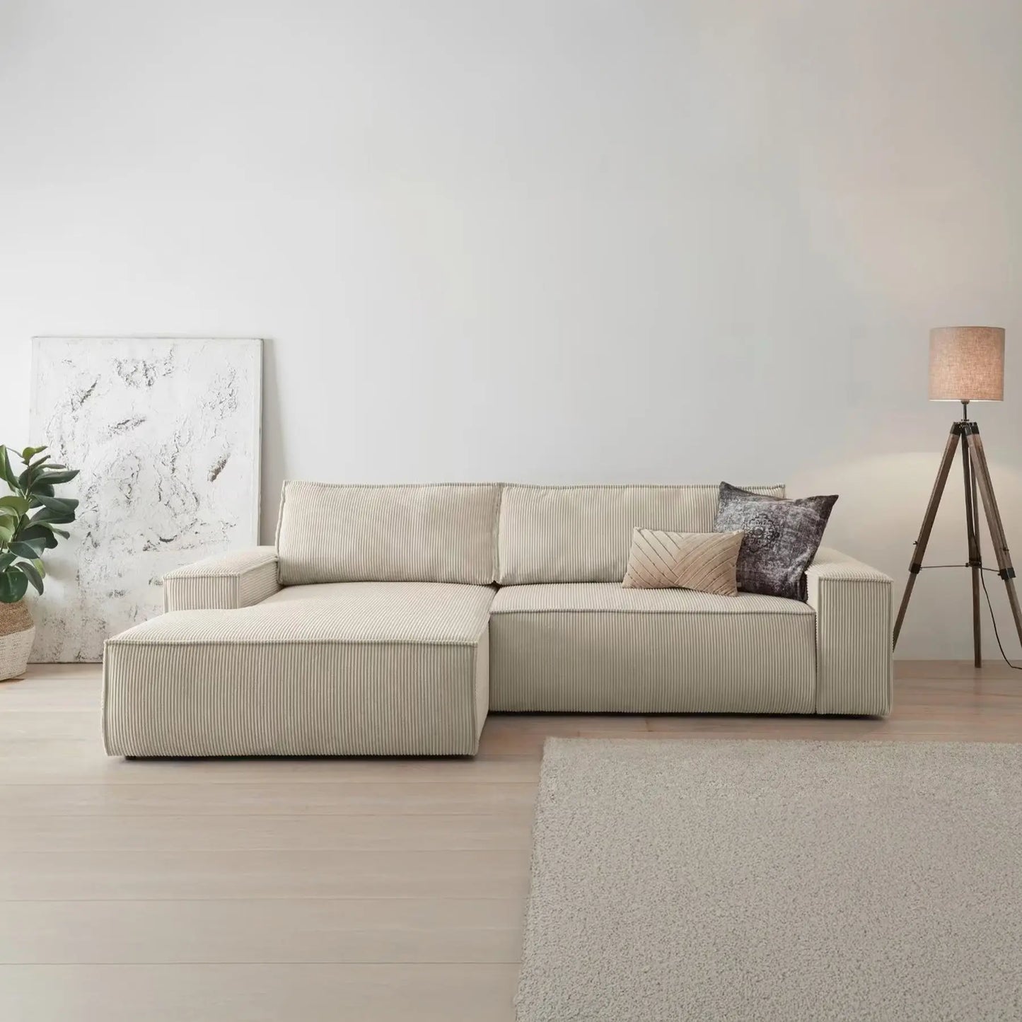 Beiges Ecksofa mit Cordbezug vor weißer Wand
