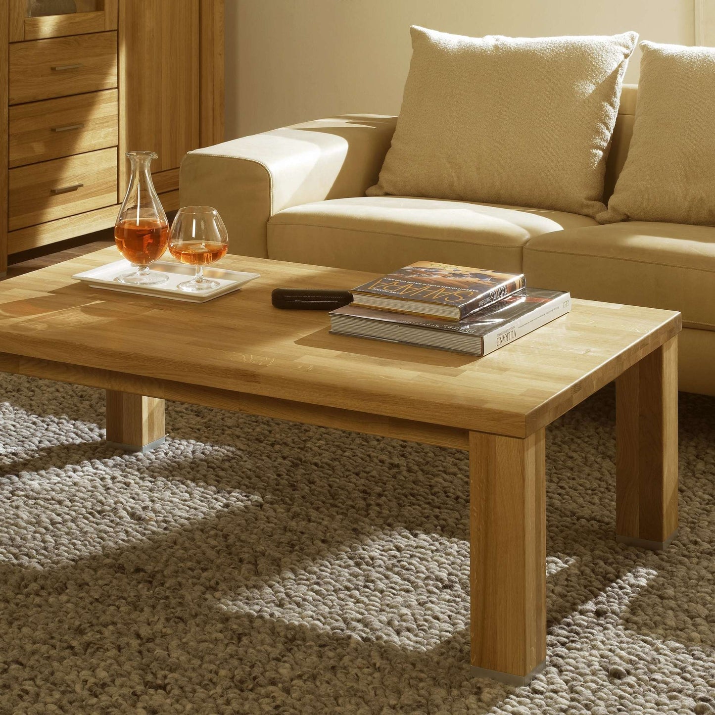 Couchtisch aus massiver Eiche mit Couchgarnitur im Hintergrund