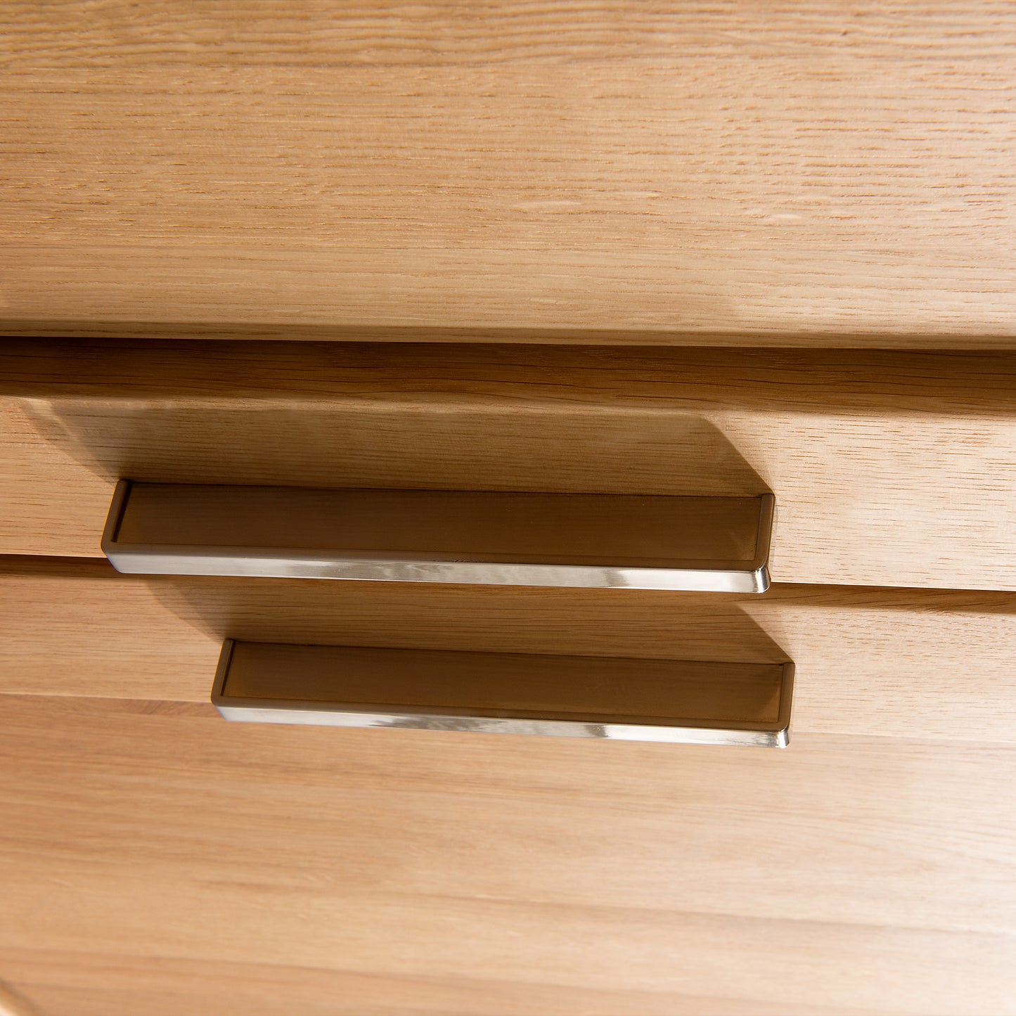 
                  
                    Detailbild silberne Griffe einer Schublade aus Holz
                  
                
