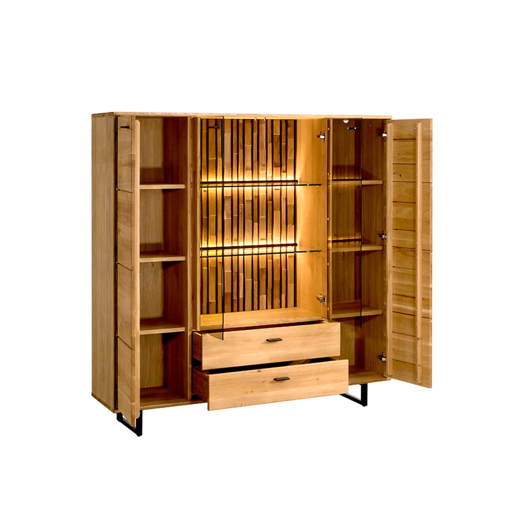 
                  
                    Hohes Highboard mit beeindruckender Präsenz
Das Highboard Tramonto hoch ist die ideale Lösung für alle, die großzügigen Stauraum mit stilvollem Design kombinieren möchten. Mit vier Türen, zwei Schubladen und einer beleuchteten Glasvitrine in der Mitte wird das Möbelstück zum stilprägenden Element in jedem Raum – sei es im Essbereich, Wohnzimmer oder großzügigen Flur.

Glasvitrine mit Struktur und Tiefe
Die mittig integrierte Vitrine mit zwei Glastüren und strukturierter Rückwand bietet Platz für Gläser, Dek
                  
                