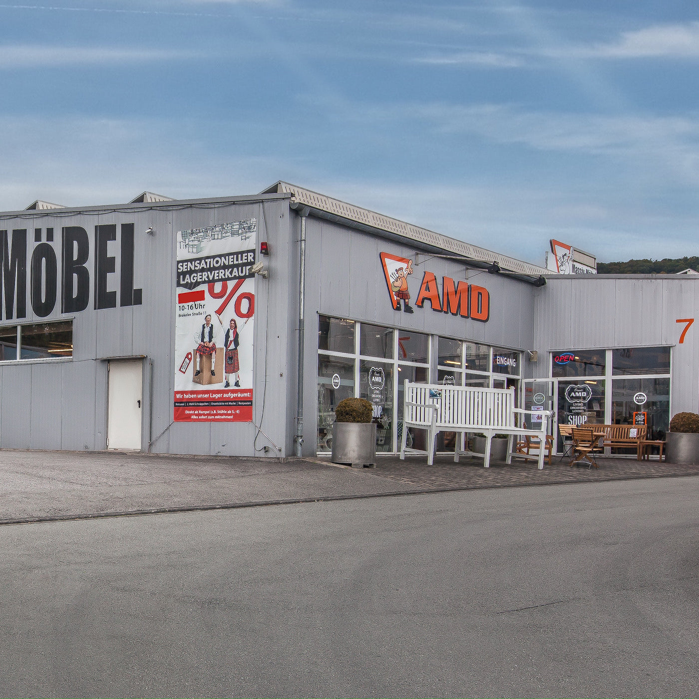 AMD Möbel Store Eingang mit großem Logo, großer Bank und einem AMD Werbebanner