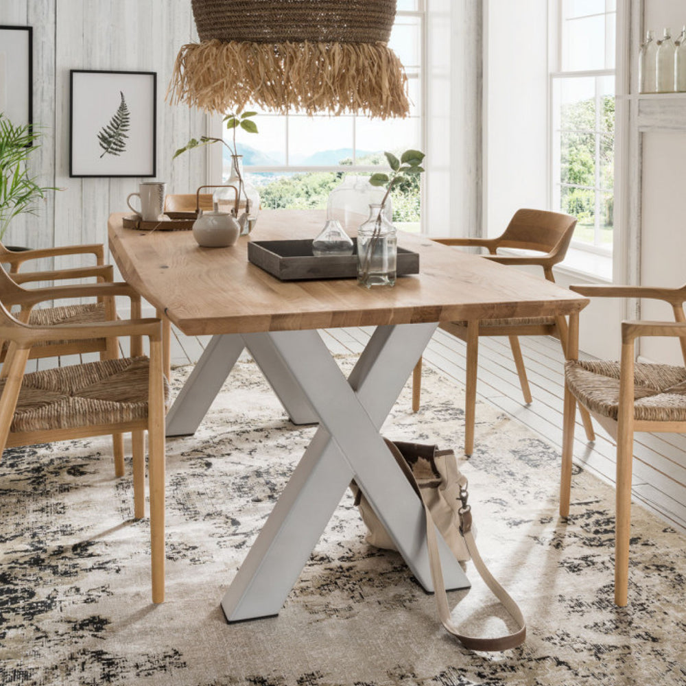Esstisch mit weißen, überkreuzten Tischbeinen und Natur Tischplatte mit geflochtenen Stühlen