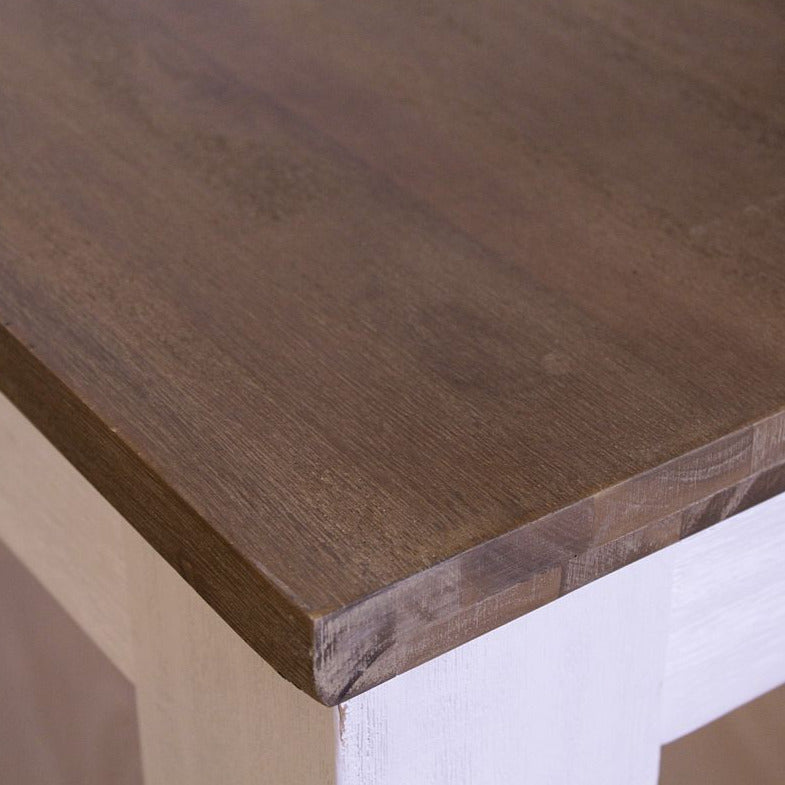 
                  
                    Tischkante aus braunem Holz und weißen Tischbeinen
                  
                